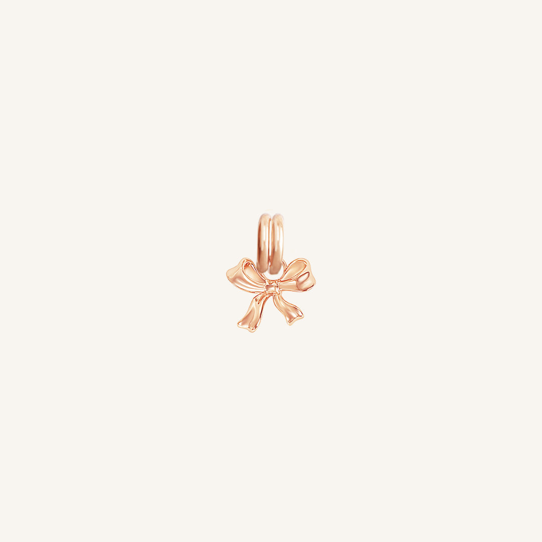 A small rose bow charm with a loop on top for attachment, displayed on a white background.