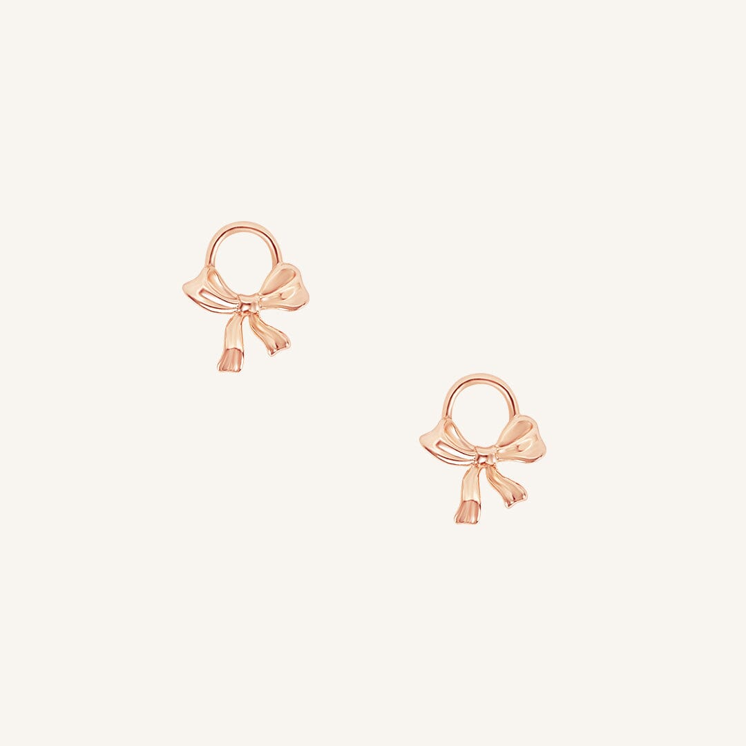 A set of two rose hoop charms with a bow design.