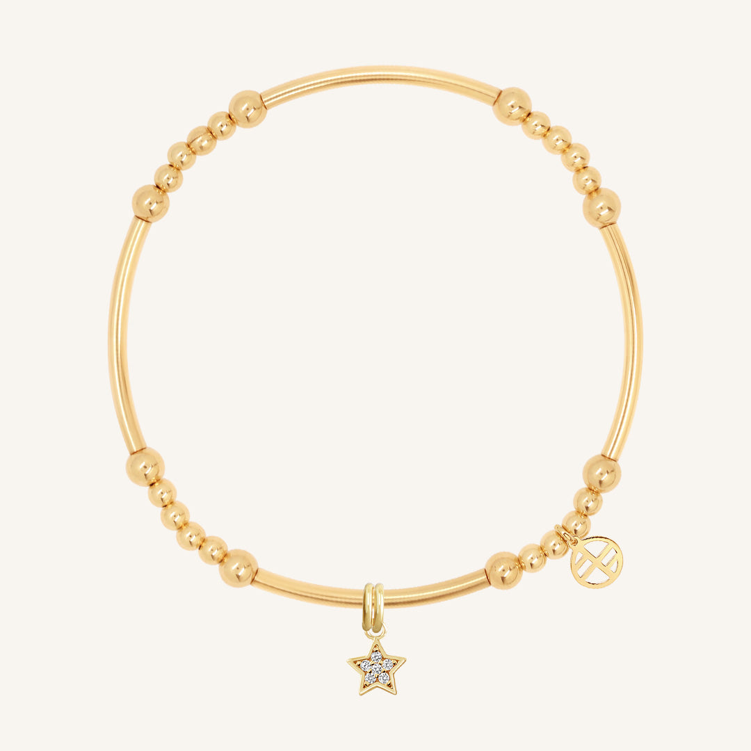 A gold-coloured bracelet with a luck star charm and small bead details.