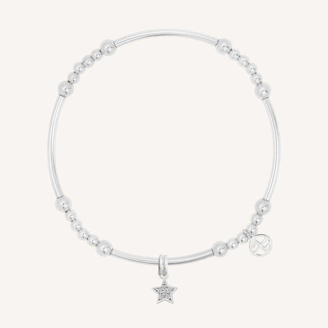 A silver-coloured bracelet with a luck star charm and small bead details.