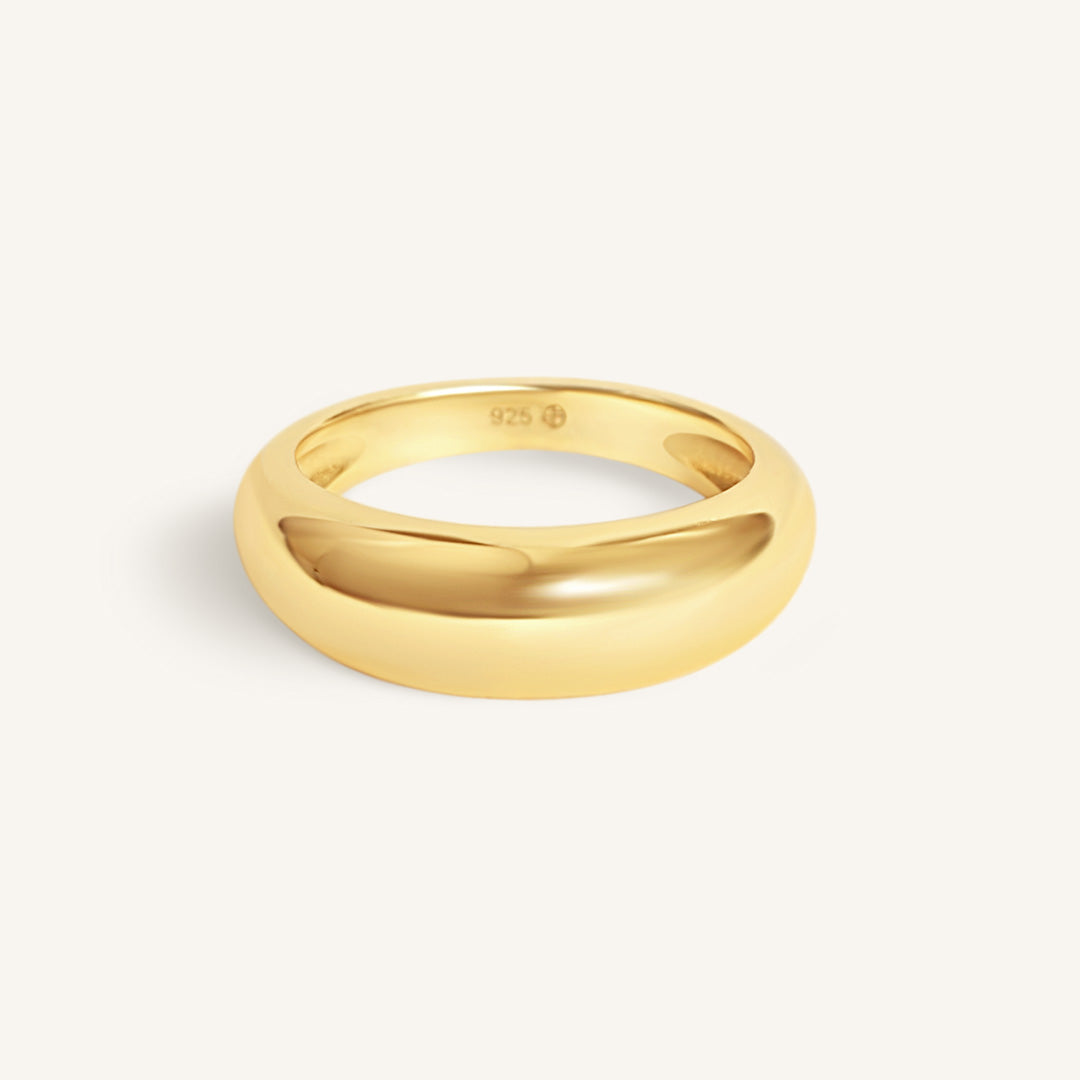 Gold ring on a light beige background
