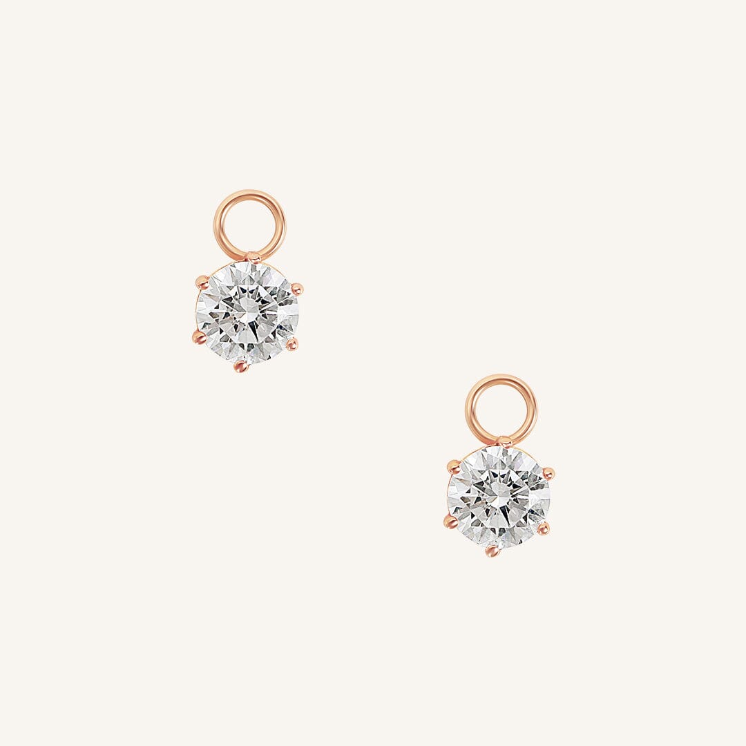 A set of two hoop charms with rose metal tone, designed to be attached to earrings.