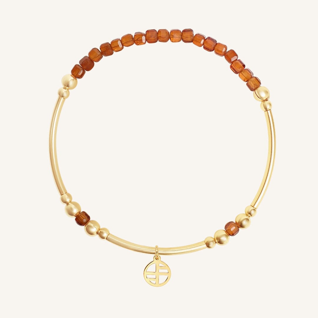Gold bracelet with brown beads on a white background
