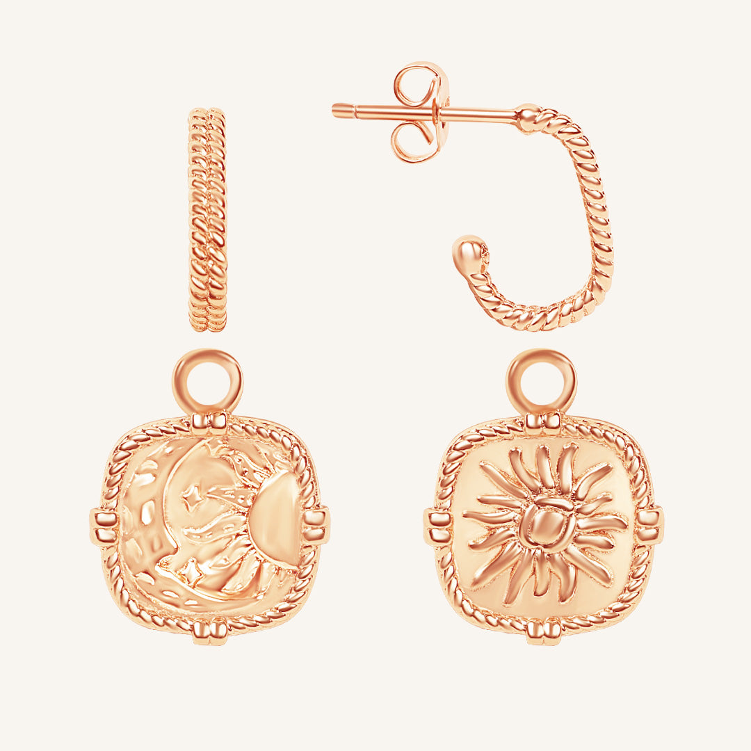 Rose gold hoop earrings with intricate designs on a light beige background