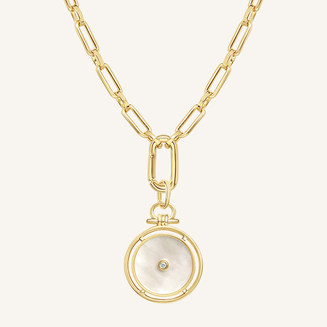 Gold necklace with a circular pendant on a white background