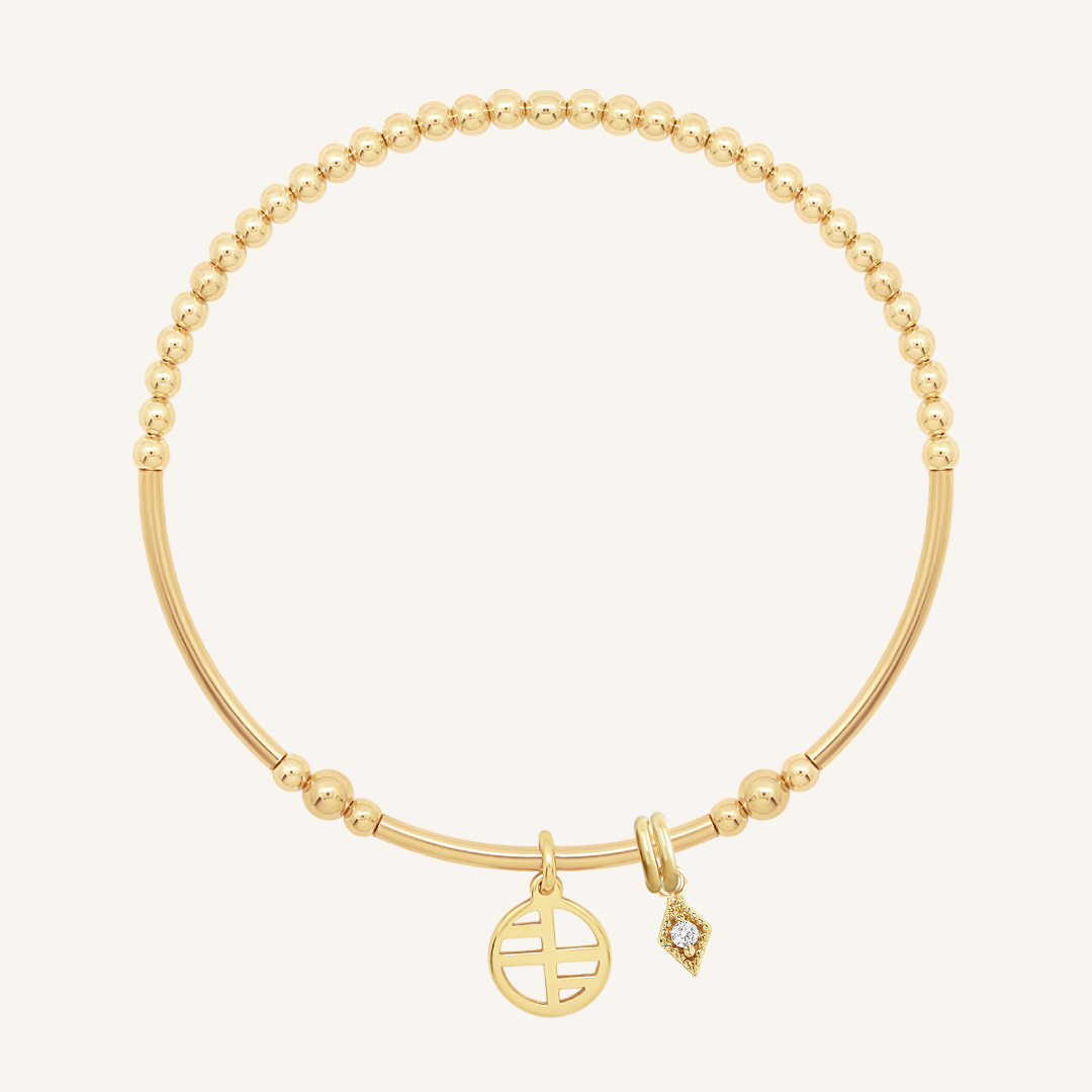 A gold-tone charm bracelet with a petite diamond charm and a stretchy bead chain.
