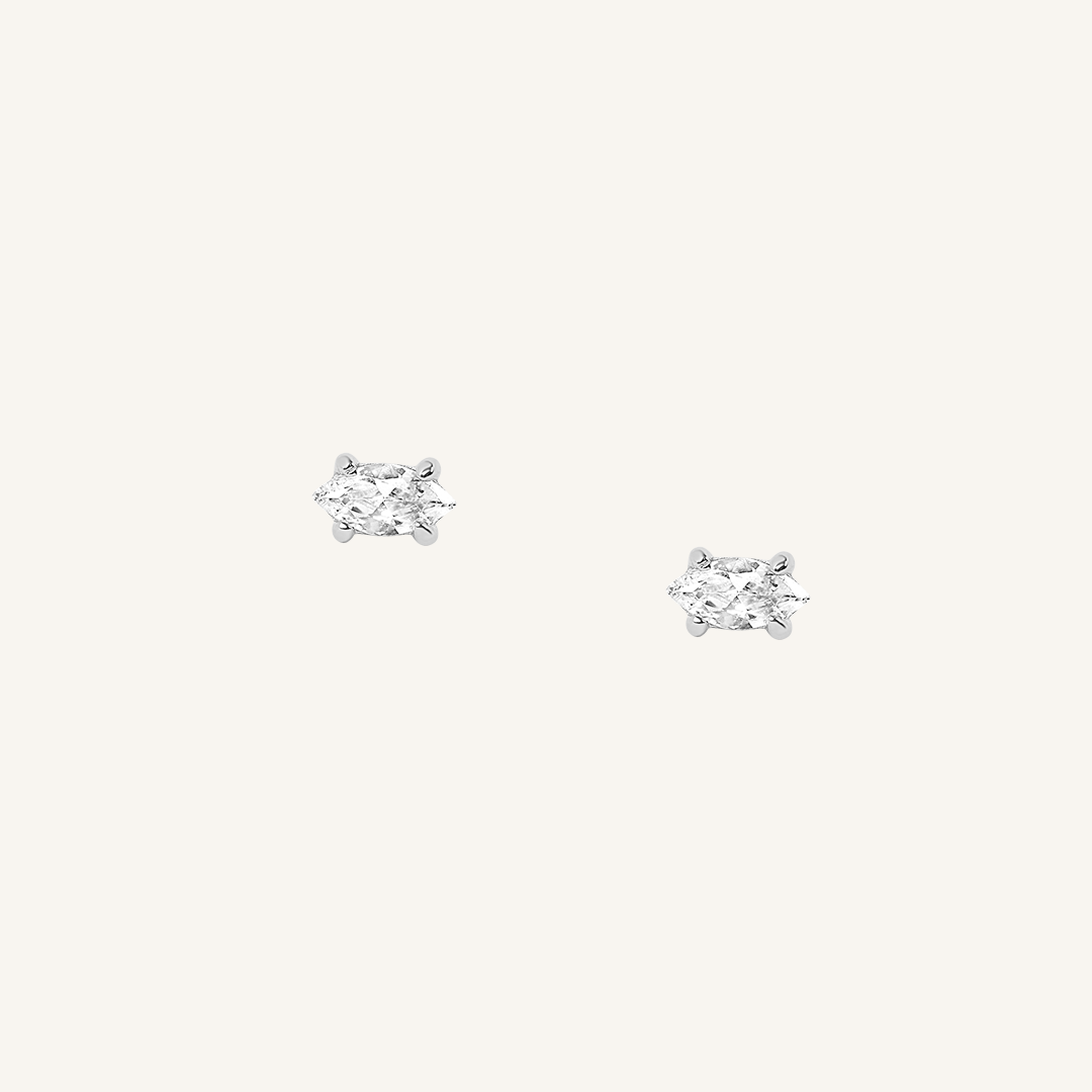 A pair of silver-colored stud earrings on a white background.