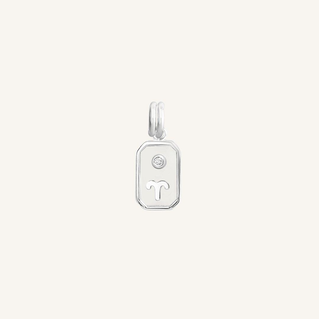 A silver rectangular shaped charm with the Aries zodiac symbol on it, designed with an iridescent finish.