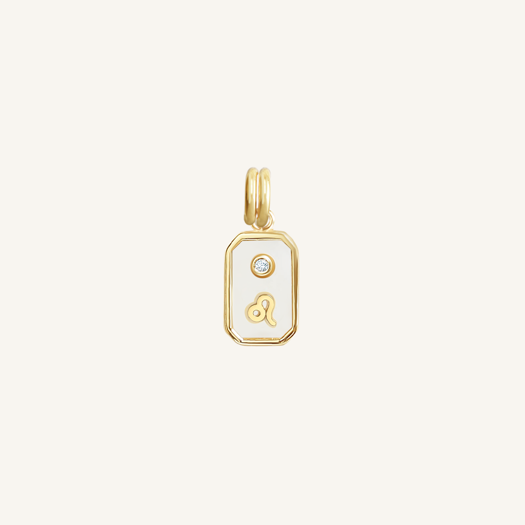 A gold rectangular shaped charm with the Leo zodiac symbol on it, designed with an iridescent finish.