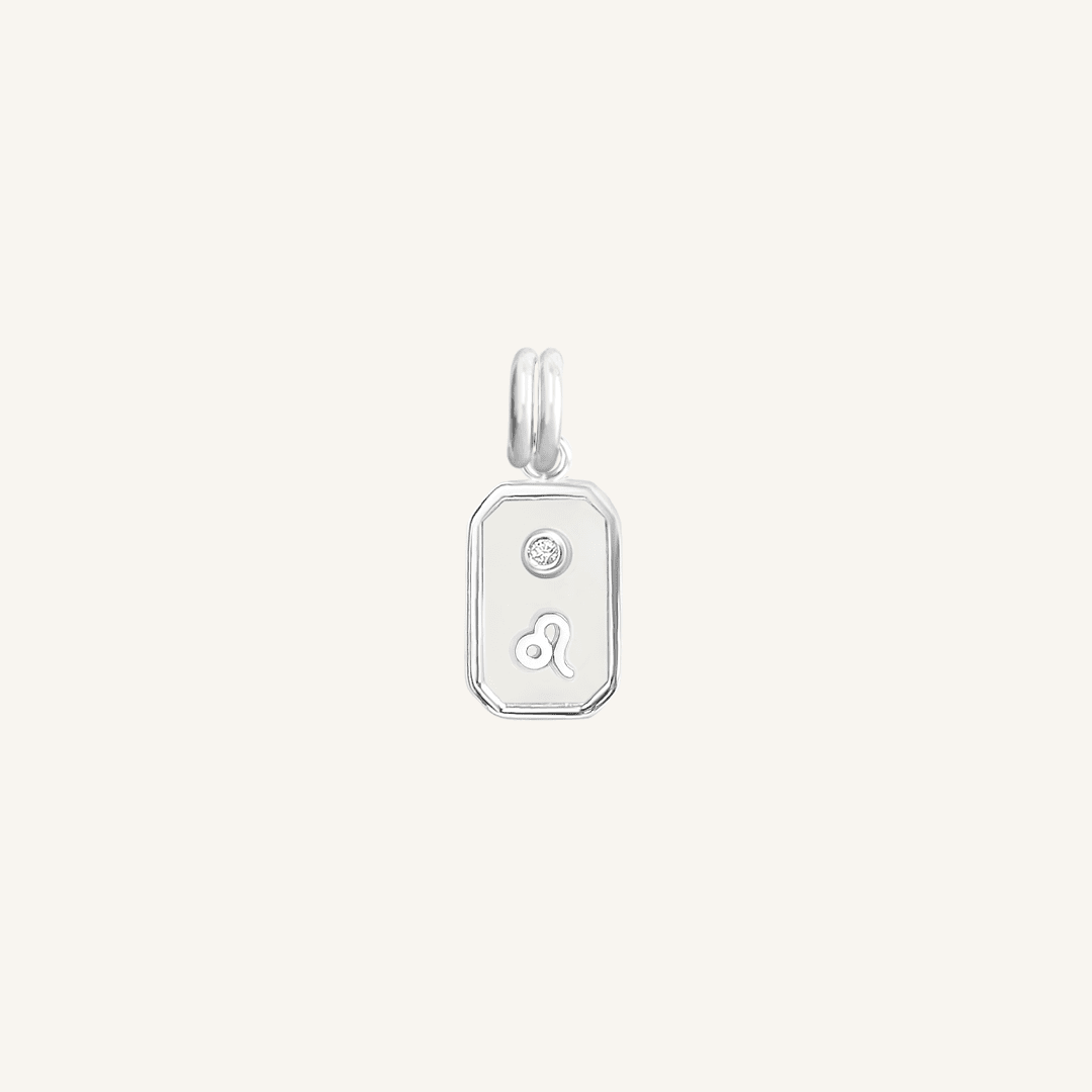 A silver rectangular shaped charm with the Leo zodiac symbol on it, designed with an iridescent finish.