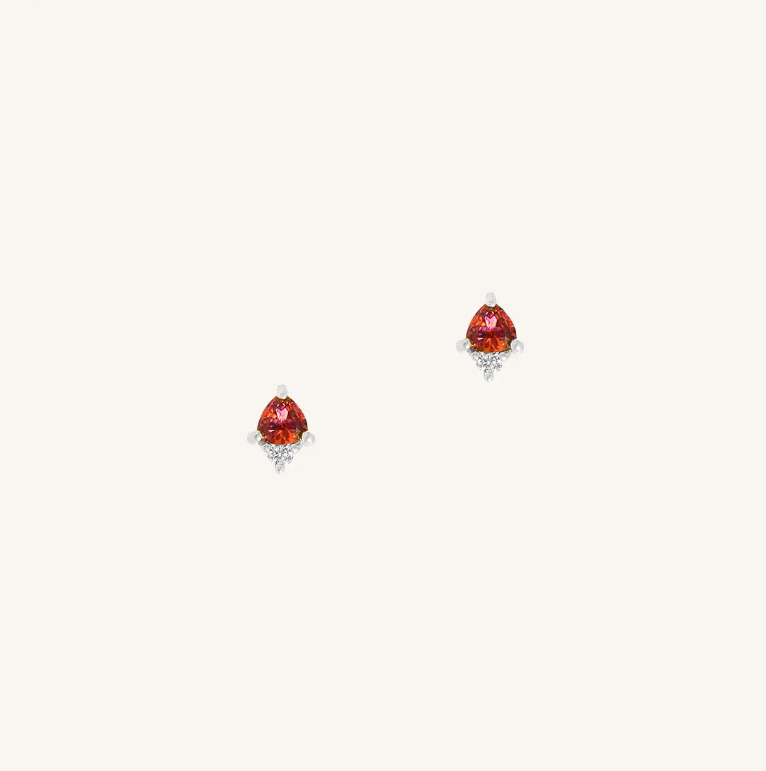 A silver pair of stud earrings featuring a red cubic zirconia, representing January.