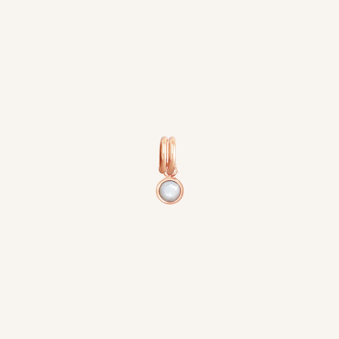 Round rose gold charm with bezel-set mother of pearl representing the June birthstone.