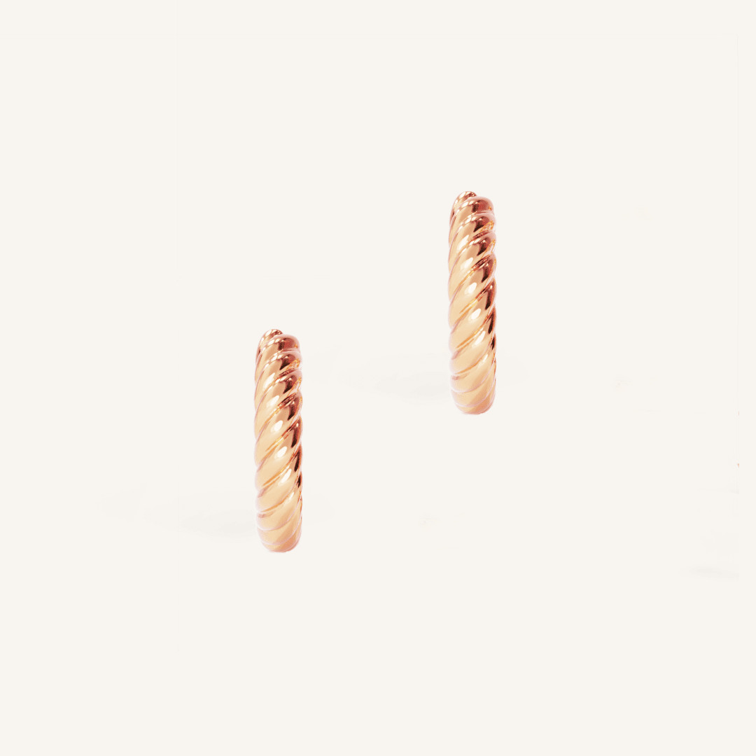 rose gold delicate hoops with a twist design on white background