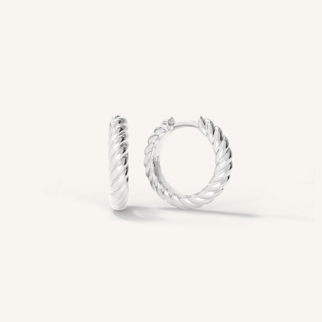 silver delicate hoops with a twist design on white background