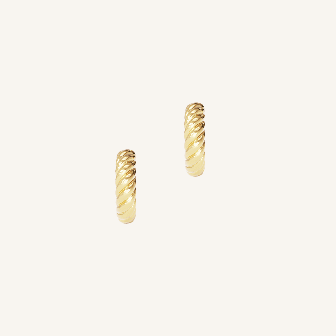 gold delicate huggies with a twist design on white background