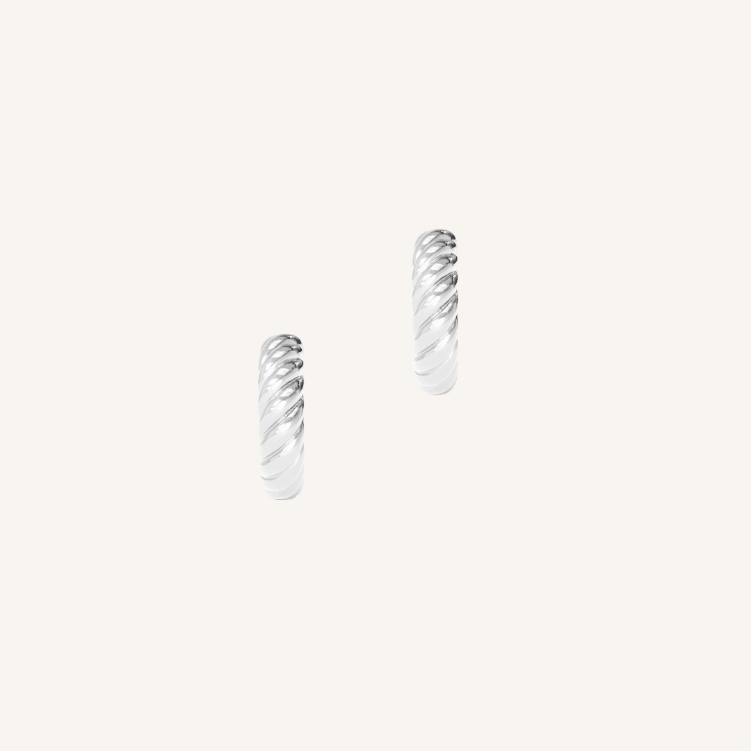 silver delicate huggies with a twist design on white background