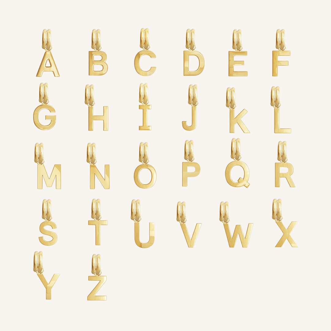 All gold letter charms on white background