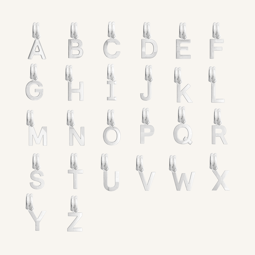 All silver letter charms on white background