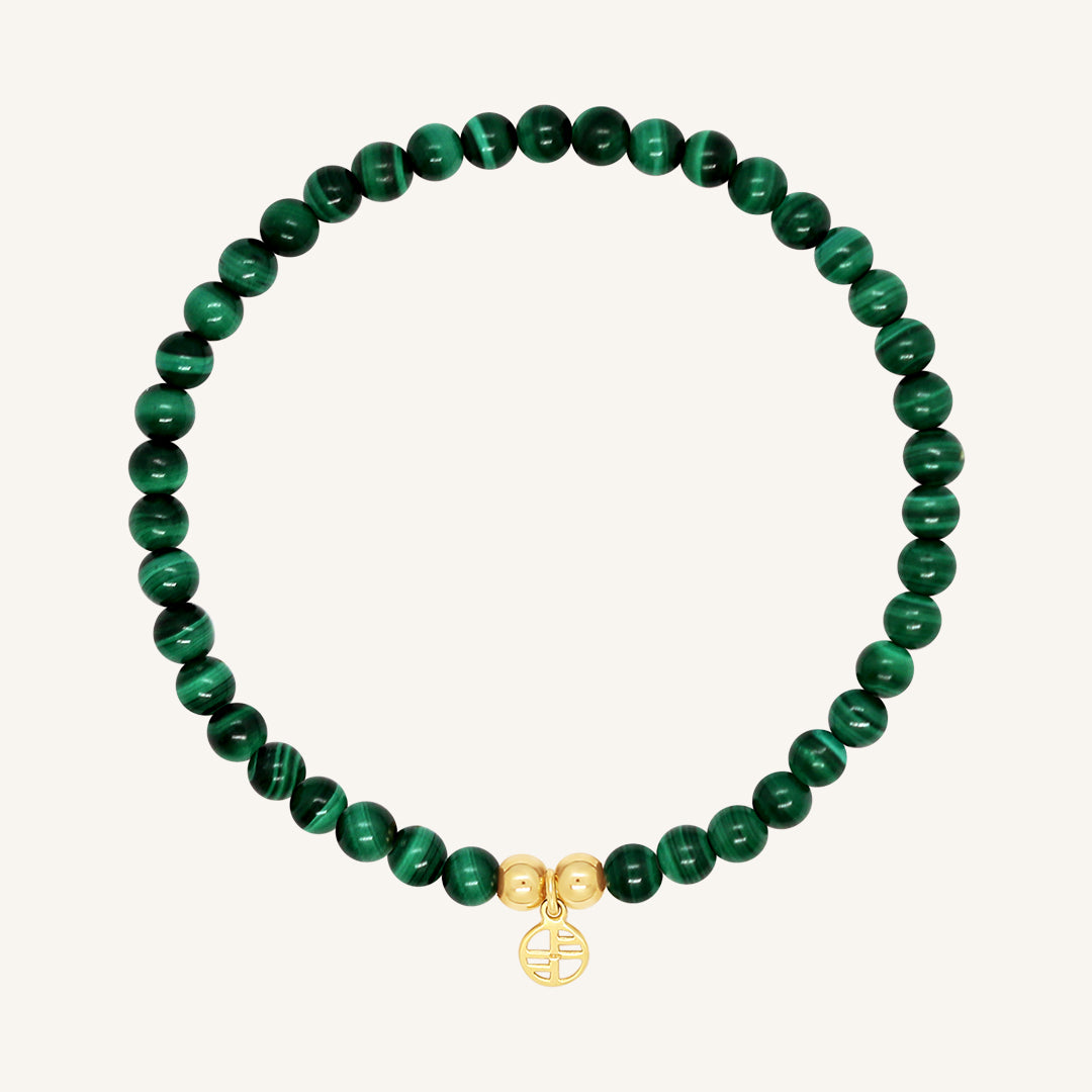 A beaded bracelet made of green malachite stones and metal beads with a gold-colored charm, displayed on a white background.