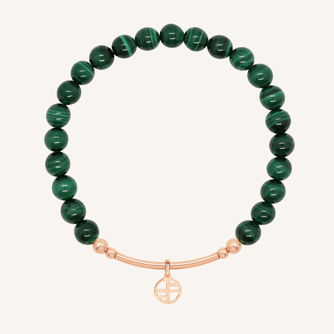 Green beaded bracelet with a rose gold bar on a white background