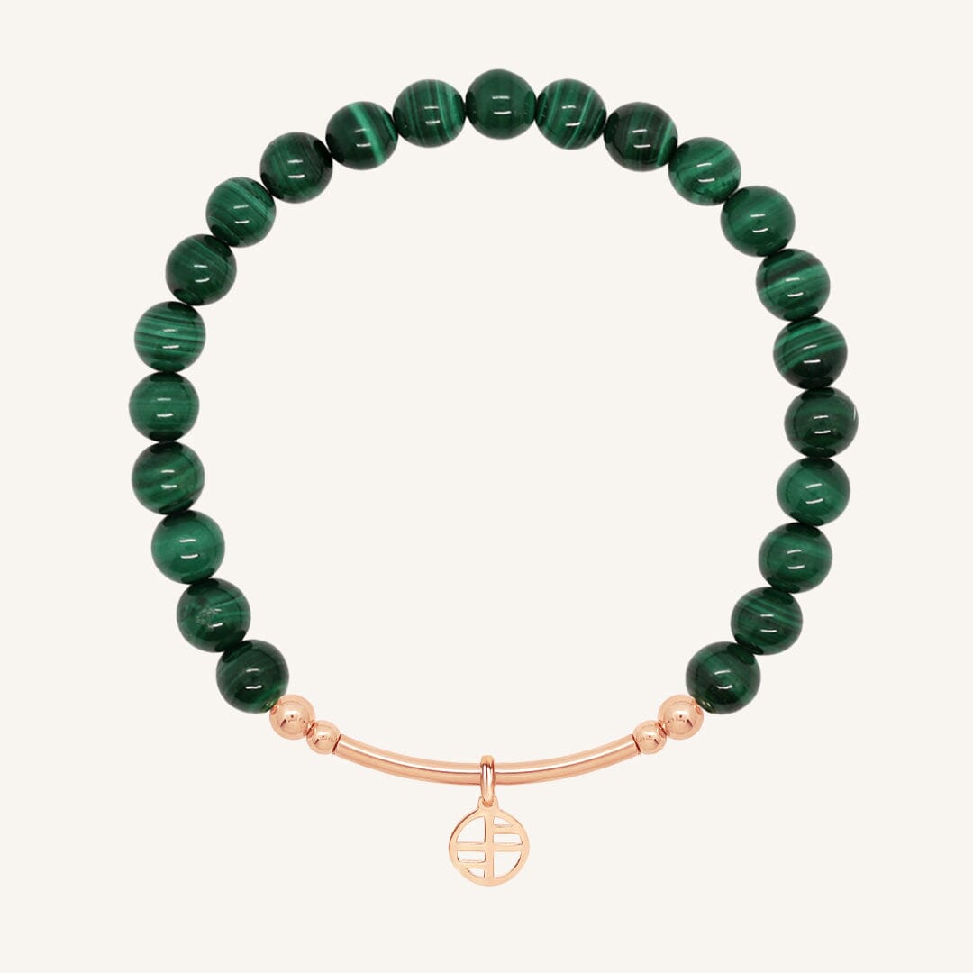Green beaded bracelet with a rose gold bar on a white background