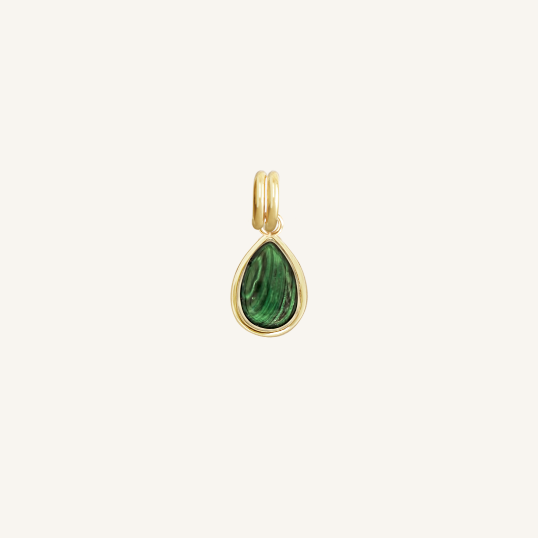 A gold charm with a teardrop-shaped malachite stone set in its centre, isolated on a white background.