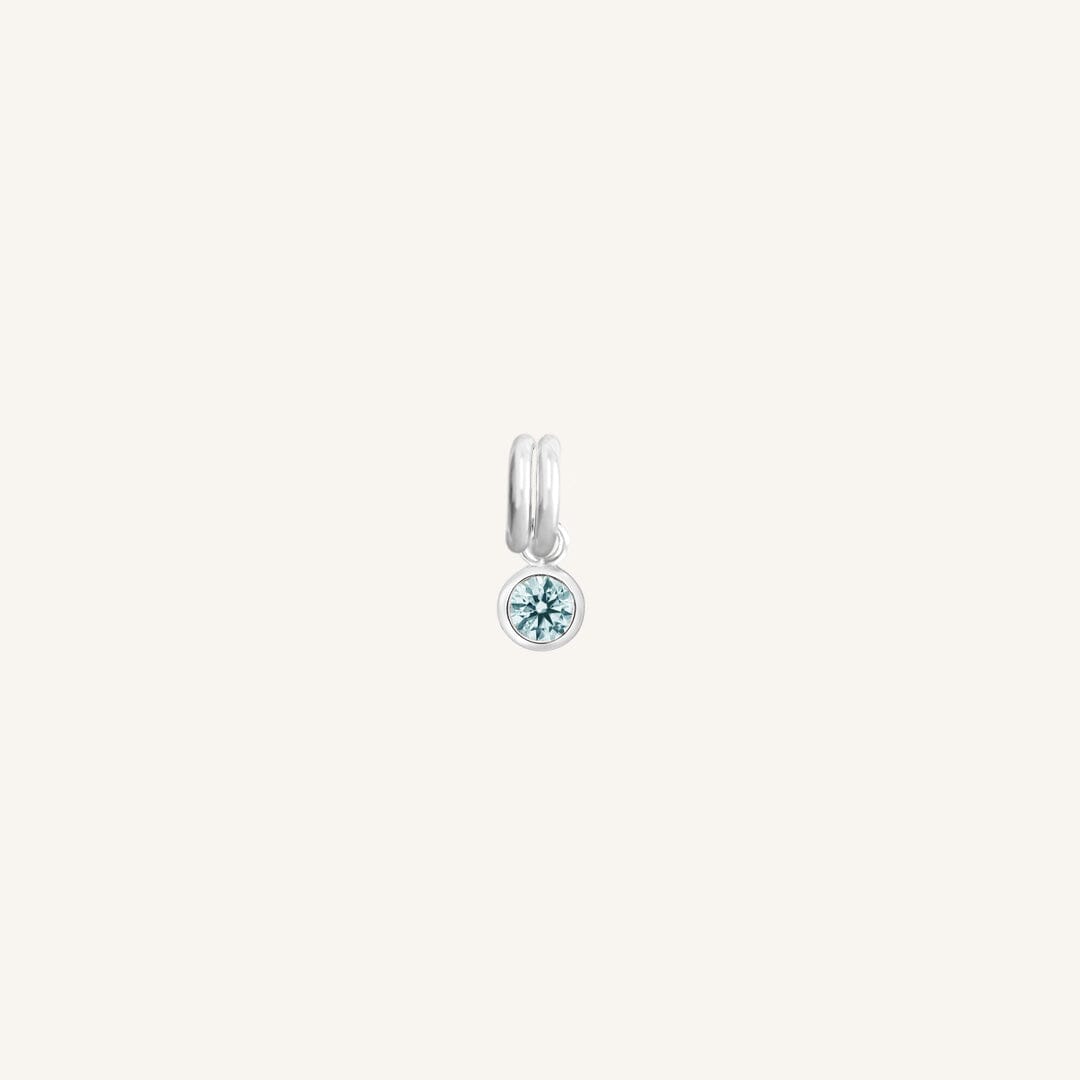 Round silver charm with bezel-set aquamarine cubic zirconia representing the March birthstone.
