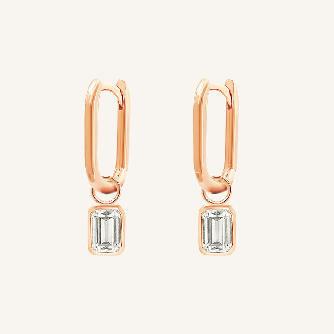 A rectangular pair of hoop charms with cubic zirconias attached to hoops