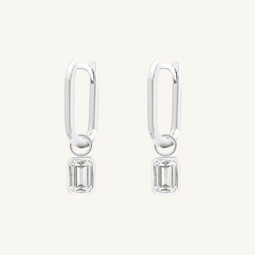A rectangular pair of hoop charms with cubic zirconias attached to hoops