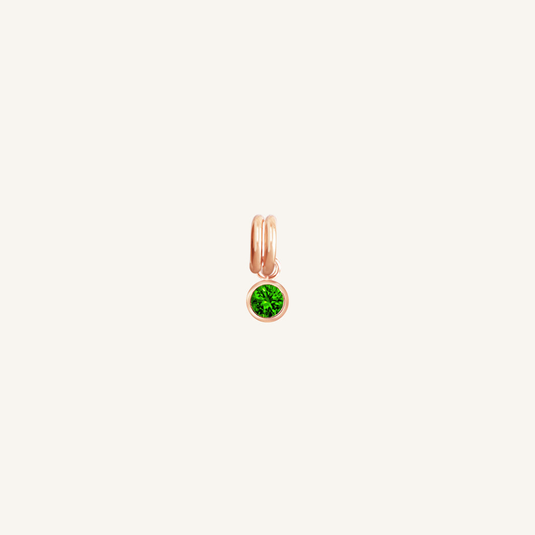 A rose gold, round bezel set emerald cubic zirconia reflects May birthstone colour