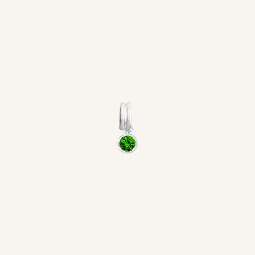 A silver, round bezel set emerald cubic zirconia reflects May birthstone colour