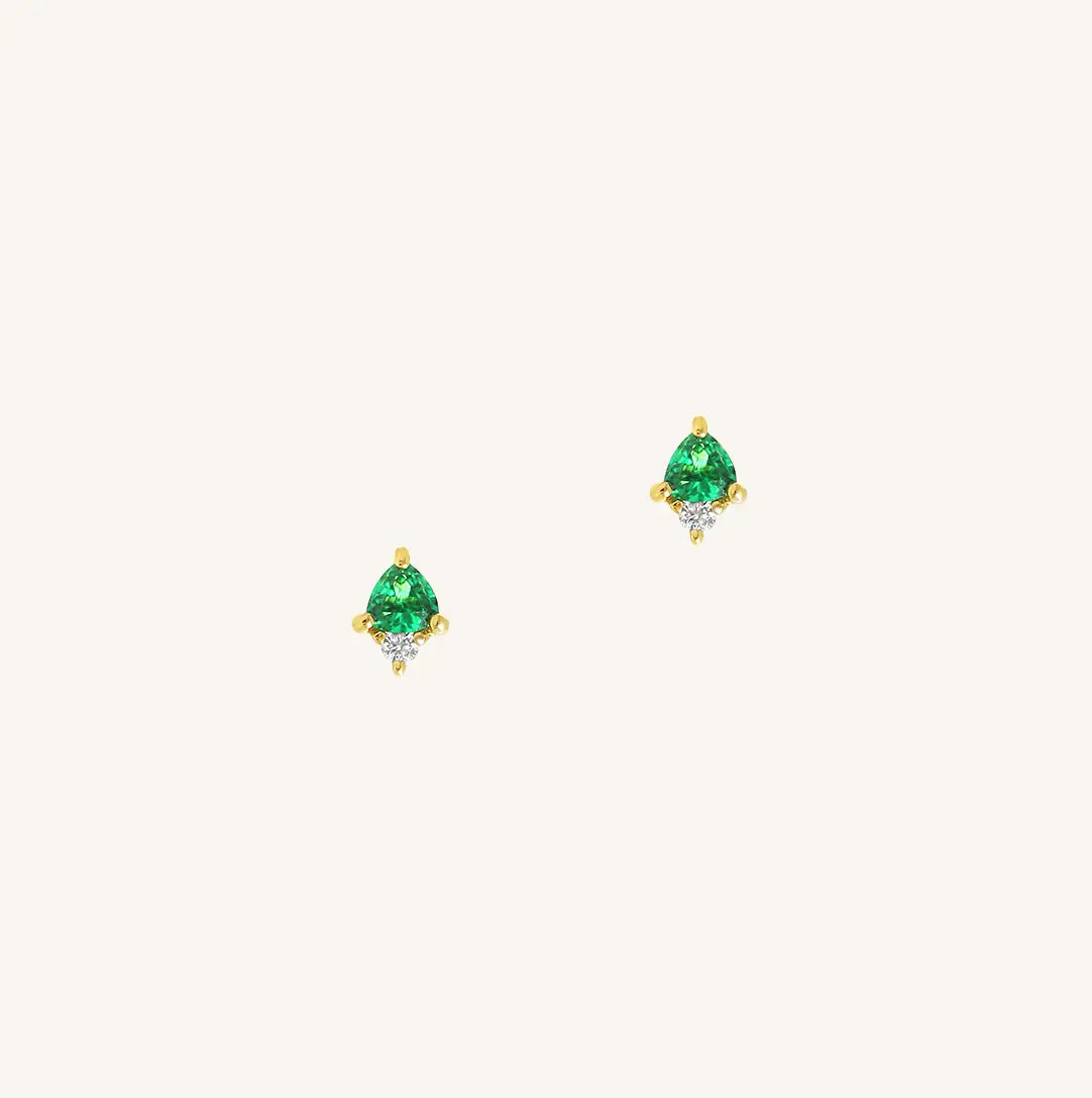 A gold pair of stud earrings featuring a green cubic zirconia, representing May.