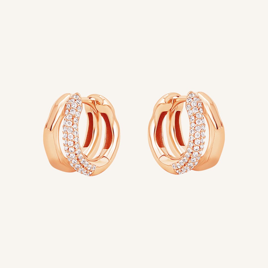 A pair of gold-colored hoop earrings with a huggie design, featuring a layered look.