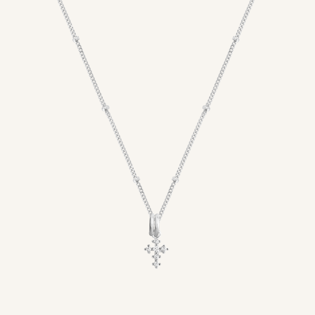 A silver-tone Nurture Cross Charm Pendant Necklace with a vintage cross shape on a chain.