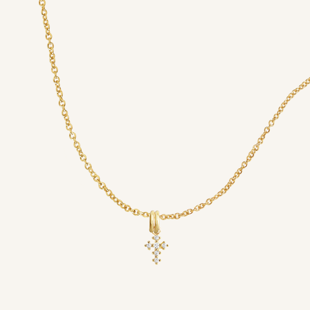 A gold-tone Nurture Cross Charm Pendant Necklace with a vintage cross shape on a chain.