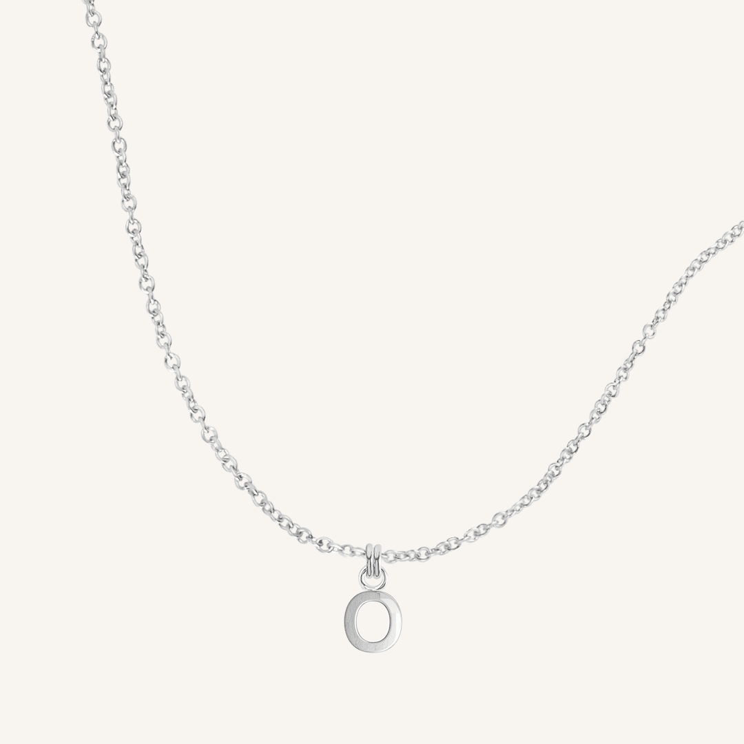 Silver necklace with an 'O' pendant on a white background