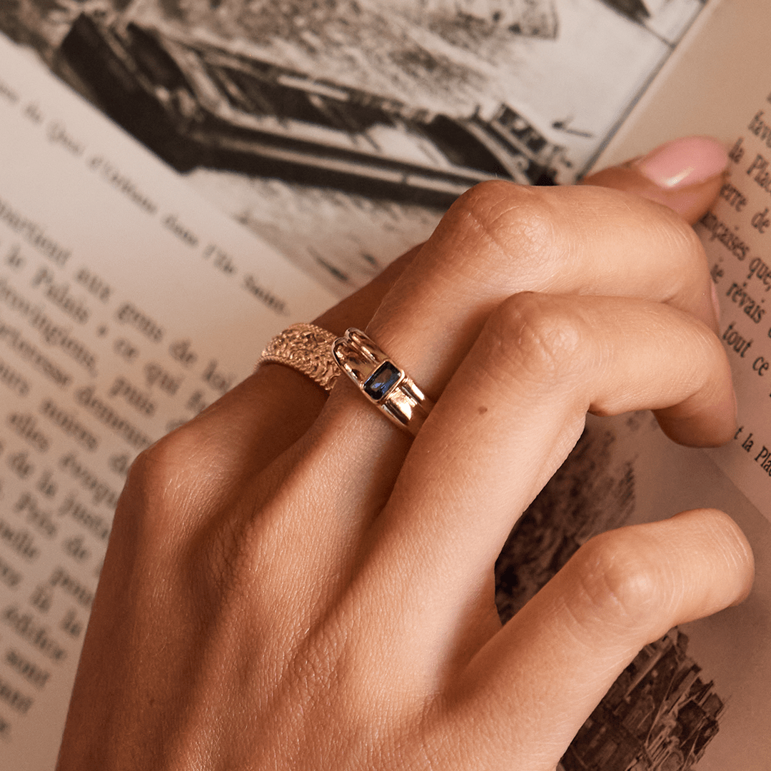 Gold ring with Navy blue cubic zirconia bezel set Inspired by the halls of Versailles close up on finger