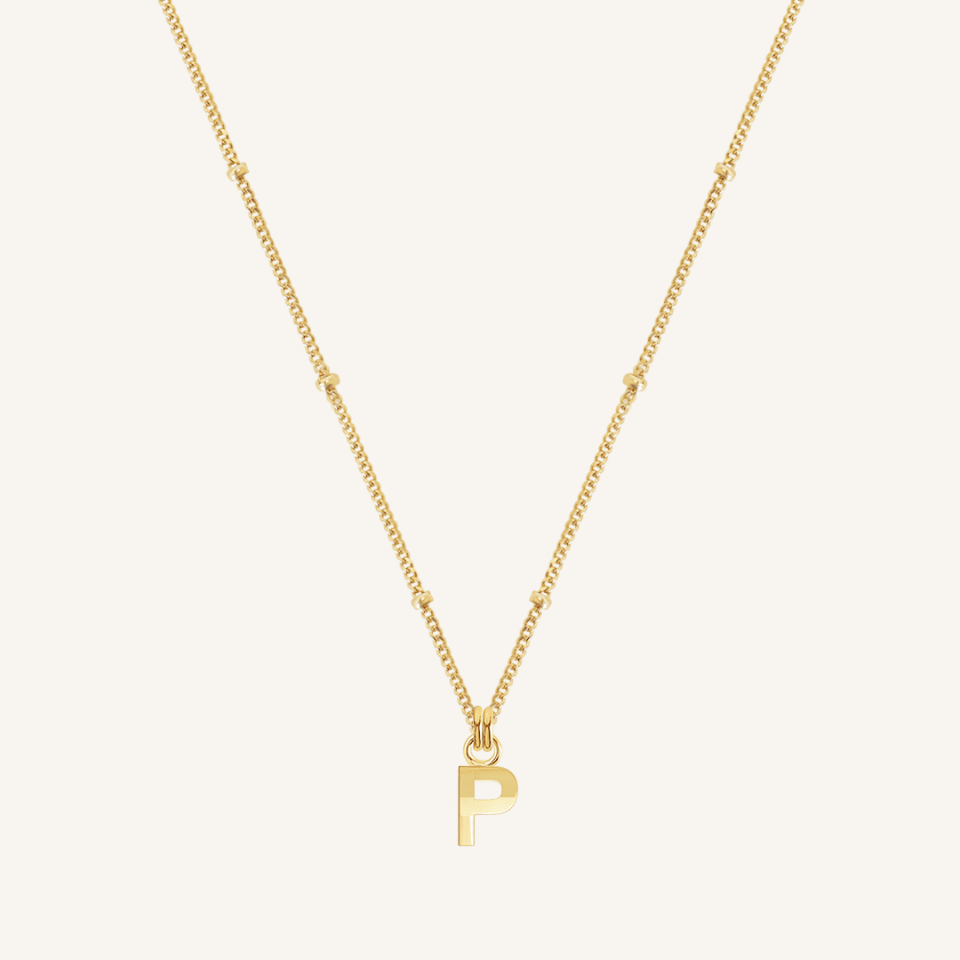 Gold necklace with a 'P' pendant on a white background