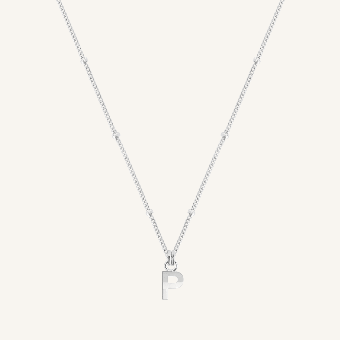 Silver necklace with a 'P' pendant on a light gray background