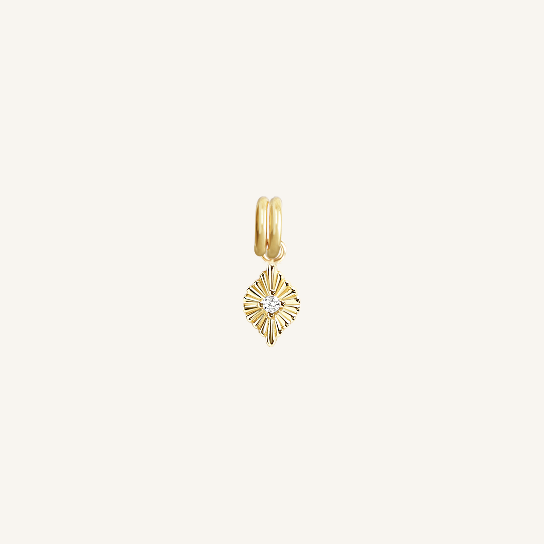 A gold birthstone charm with a white cubic zirconia representing the month of April.