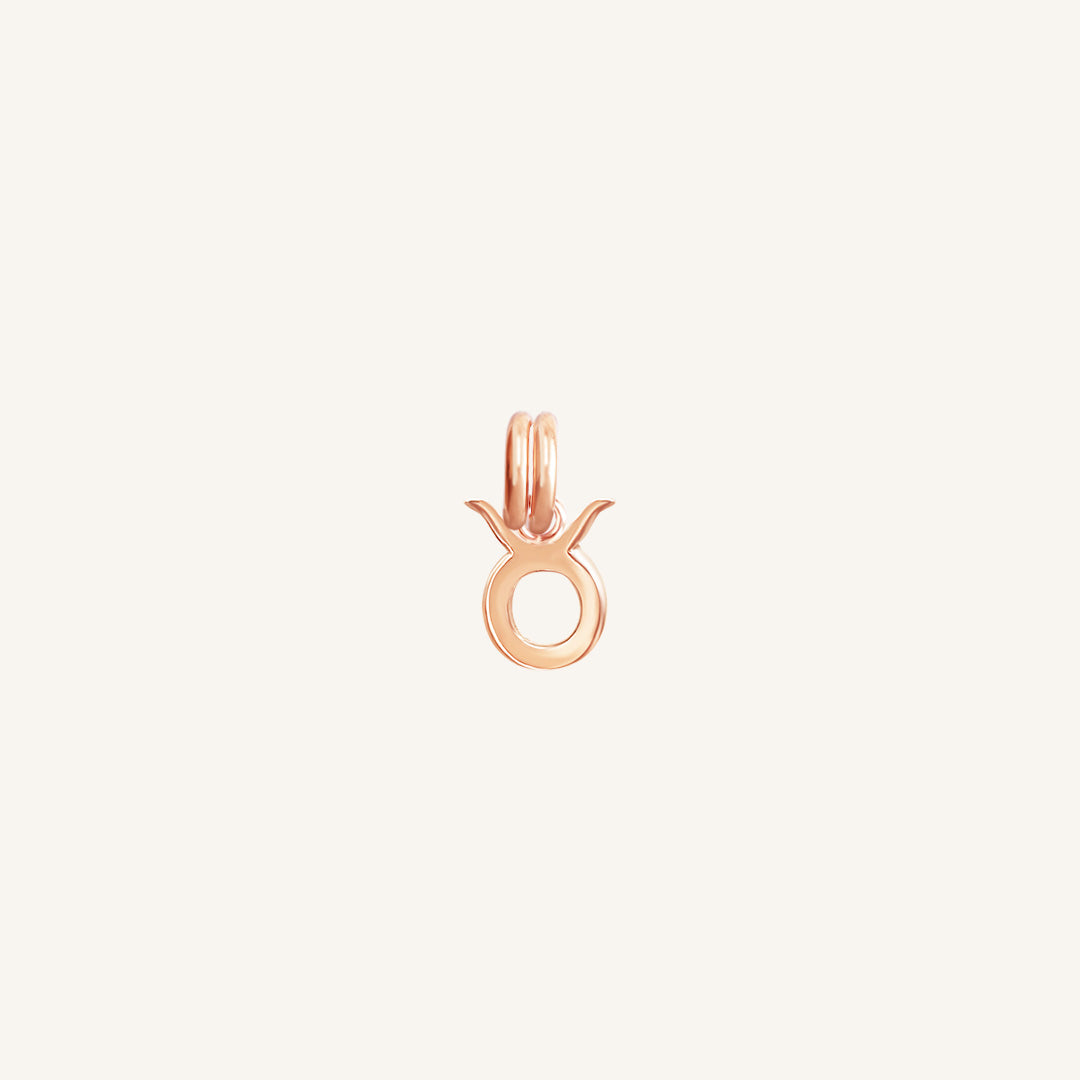 A rose gold-coloured Petite Zodiac Charm representing the Taurus sign.