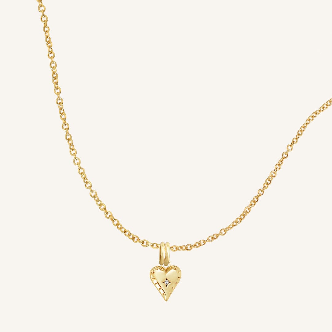 A gold-tone heart-shaped charm necklace with an adjustable chain.