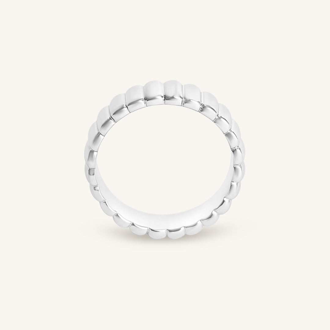 Silver ring with beaded design on a white background