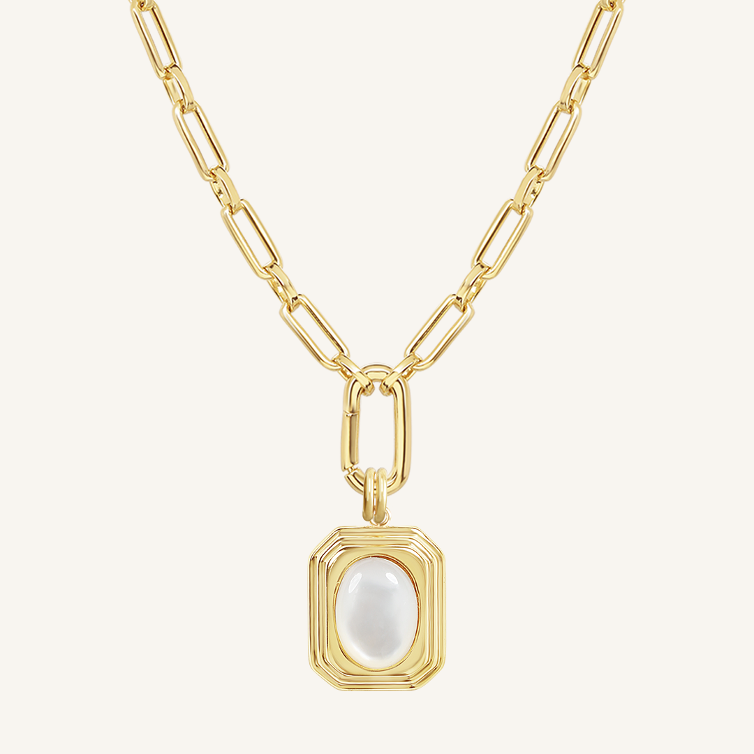 A gold-colored necklace with a square-shaped pendant featuring a mother-of-pearl stone.
