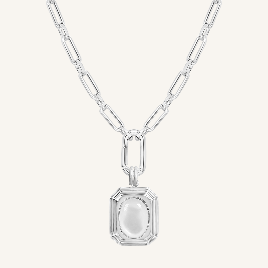 A silver-colored necklace with a square-shaped pendant featuring a mother-of-pearl stone.
