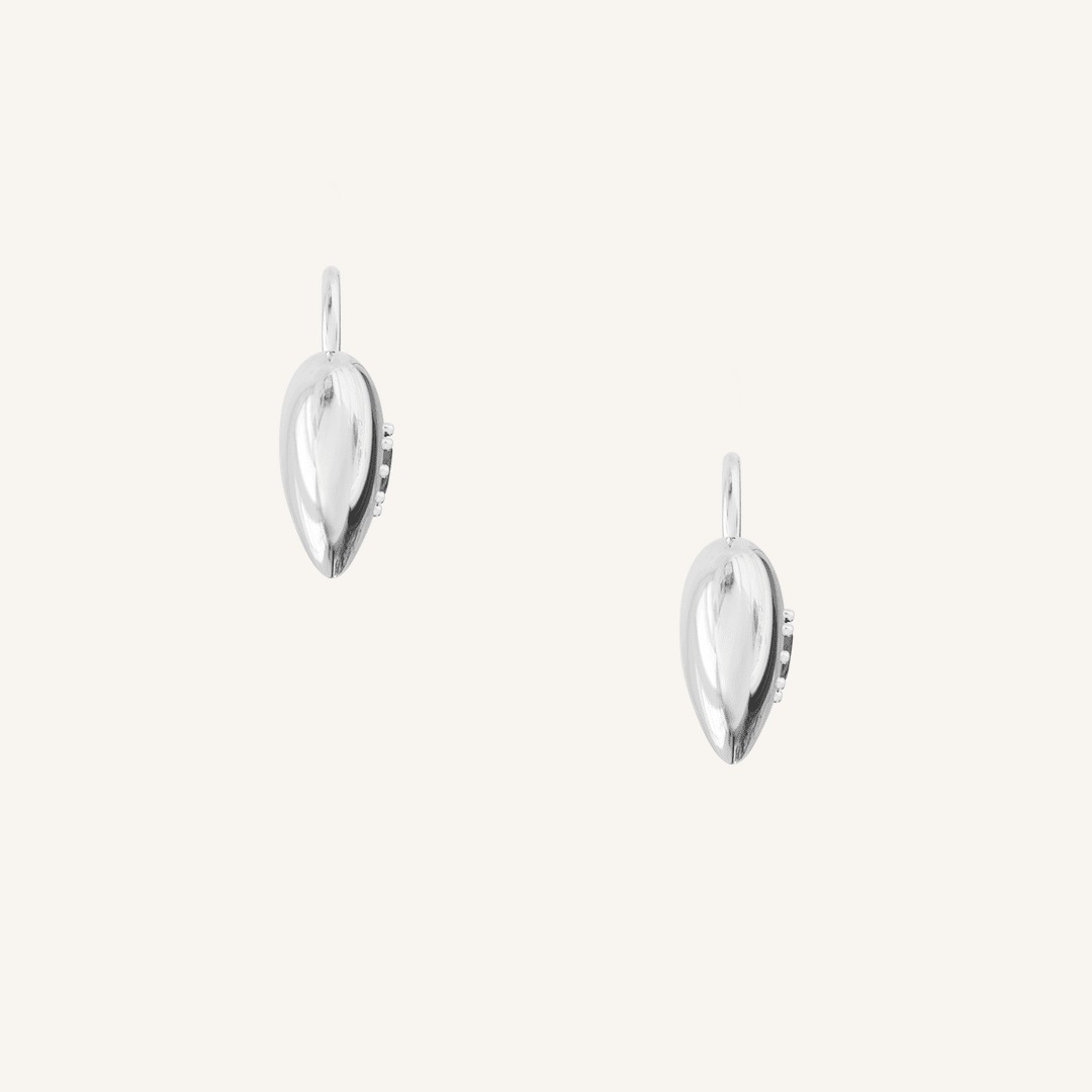 silver hoop charms with heart charms with deep red oval cubic zirconias on white background side profile