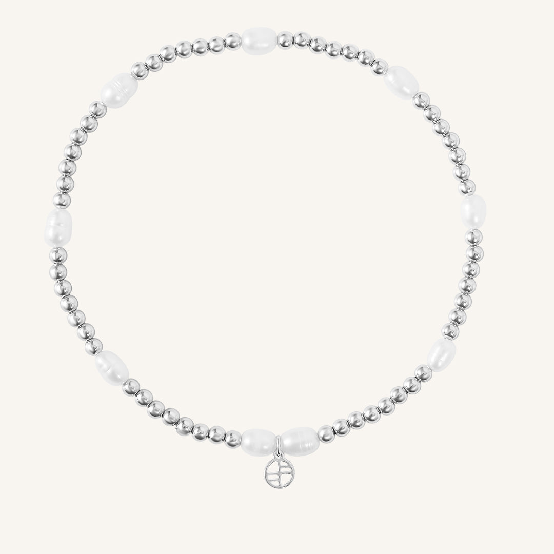 A coloured stretchy anklet with freshwater pearls and a small gold charm, displayed against a white background.