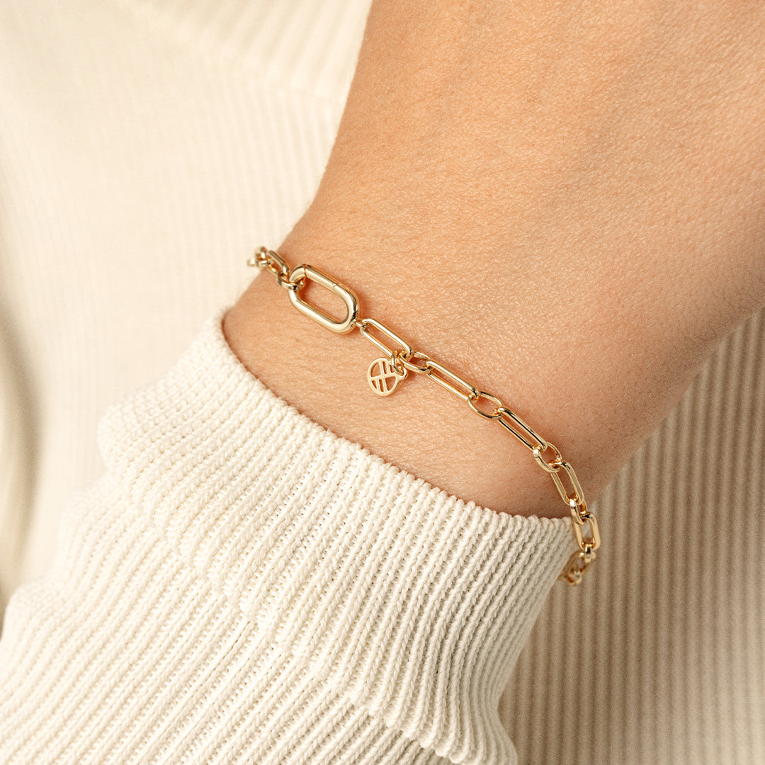 A gold-toned link bracelet, close up on wrist