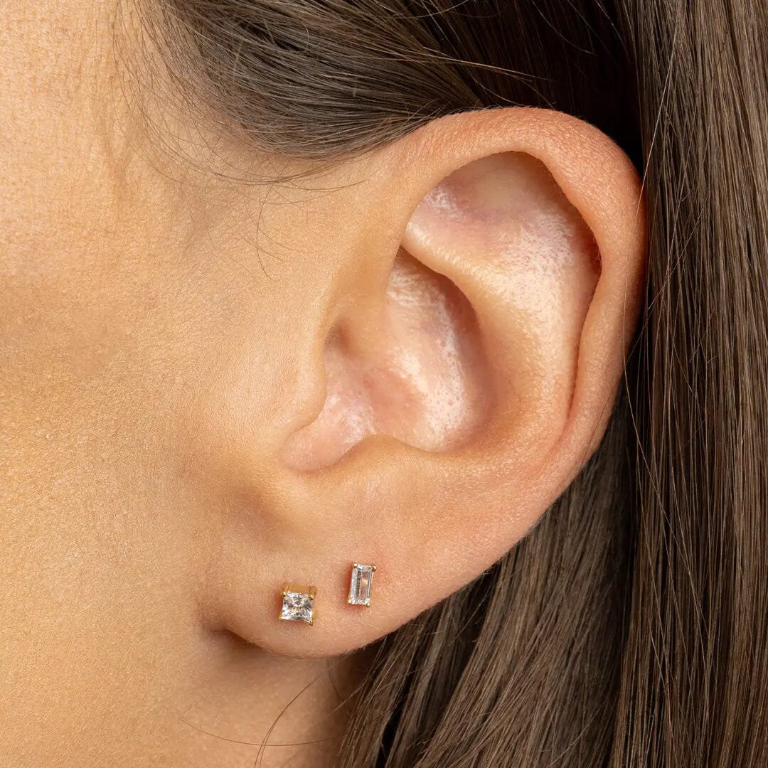 Pair of square cubic zirconia stud earrings, worn in models ear