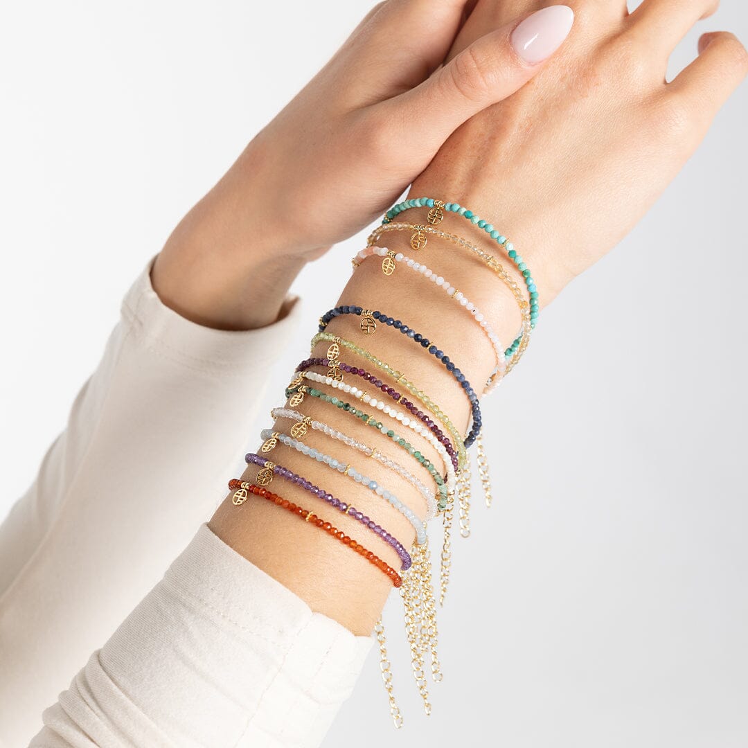 All birthstone bracelets from January to December stacked on arm